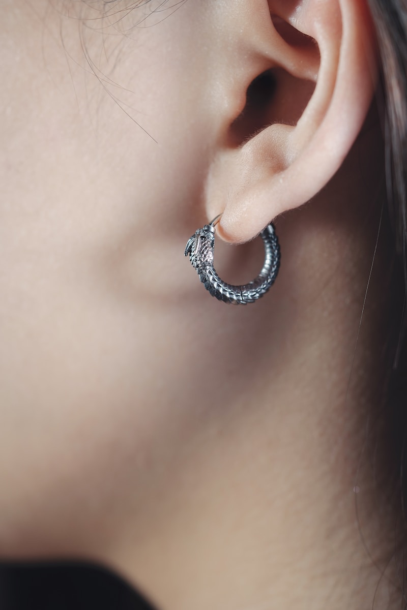 a close up of a person wearing a pair of earrings